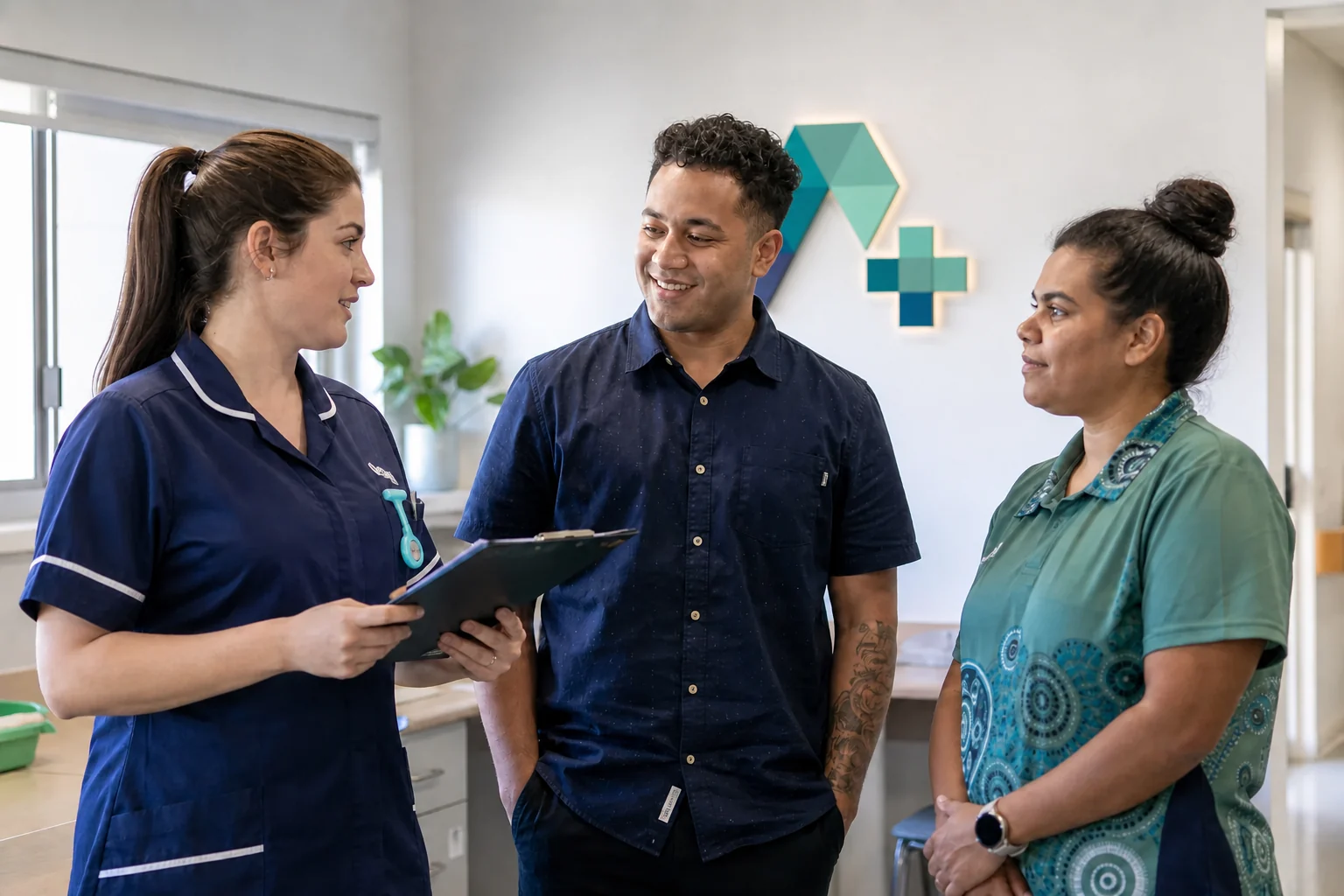 Three care professionals talking together with a dimensional AUXIO logo installed on the wall behind them