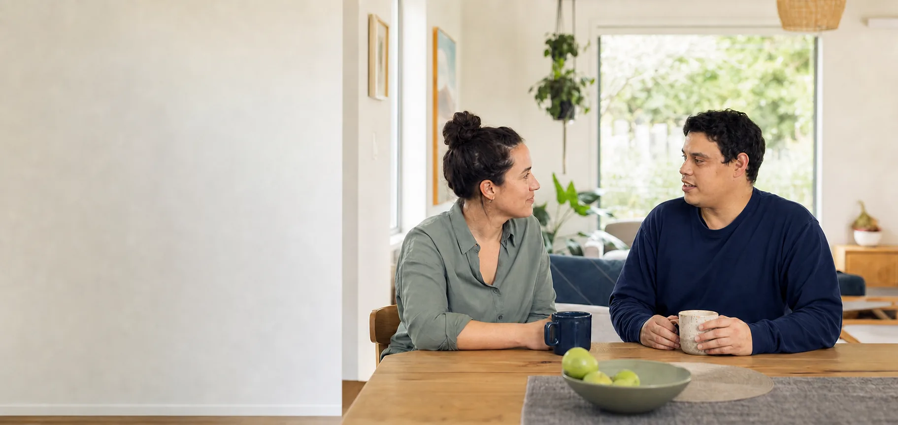 A participant and support worker talking together at home